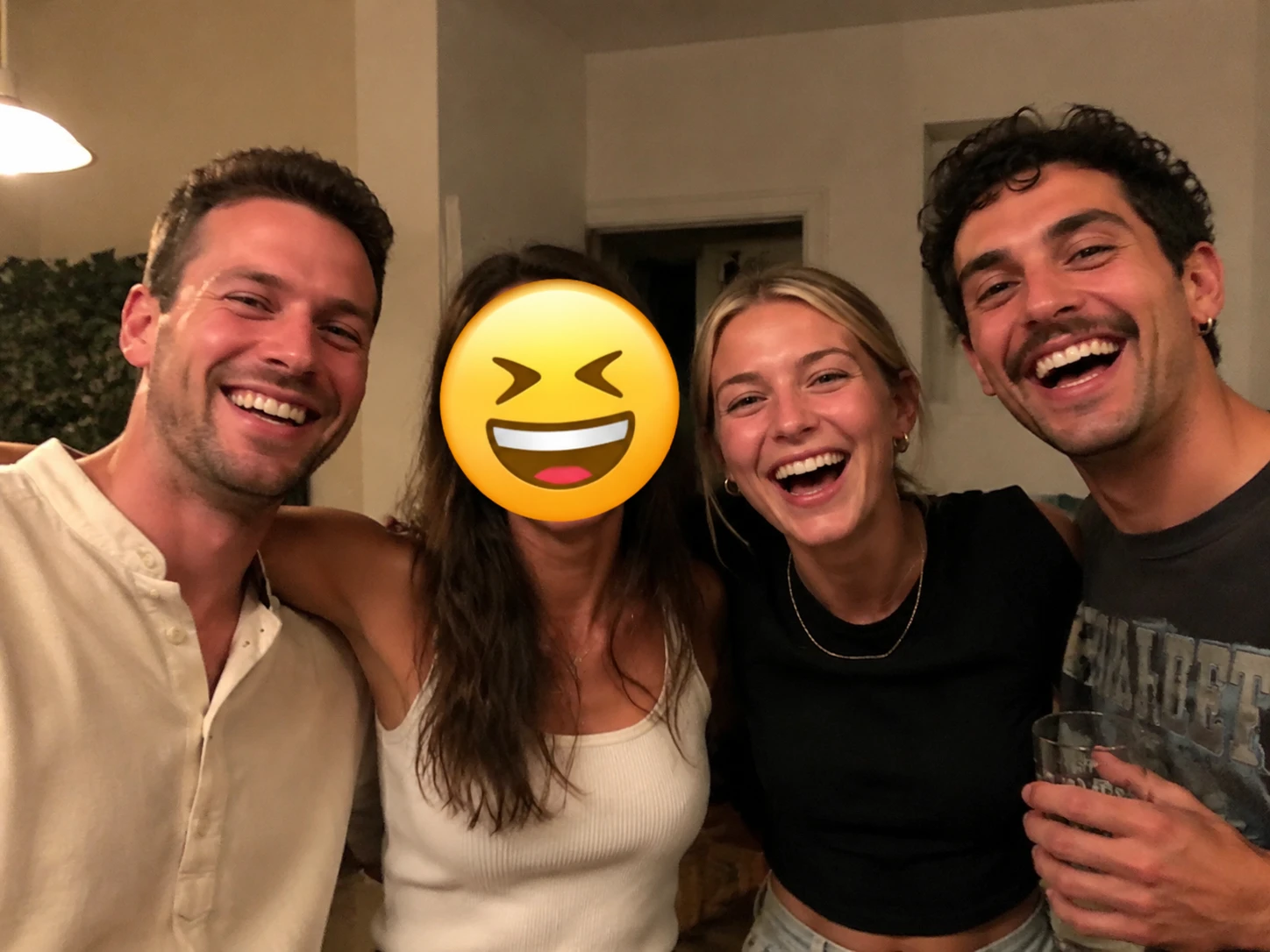 Group photo with a laughing face emoji covering one person's face