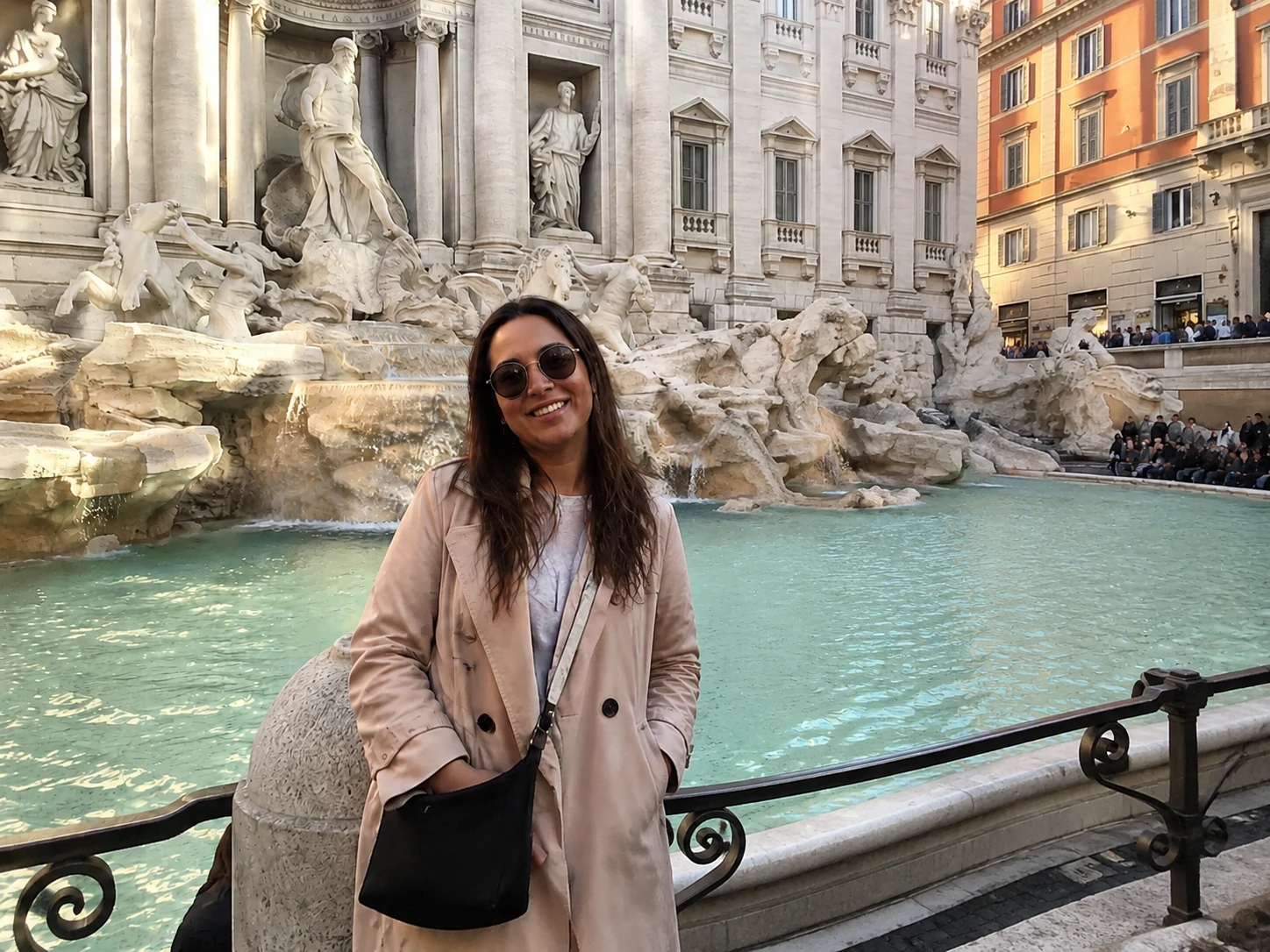 Woman posing at the Trevi Fountain in Rome, foreground cleared with the tourist removed and stone plaza restored
