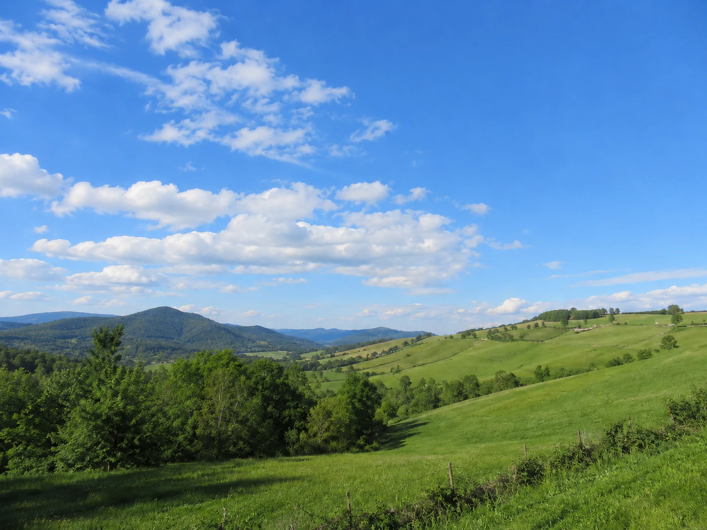 Same landscape with power lines removed, sky and hills fully restored