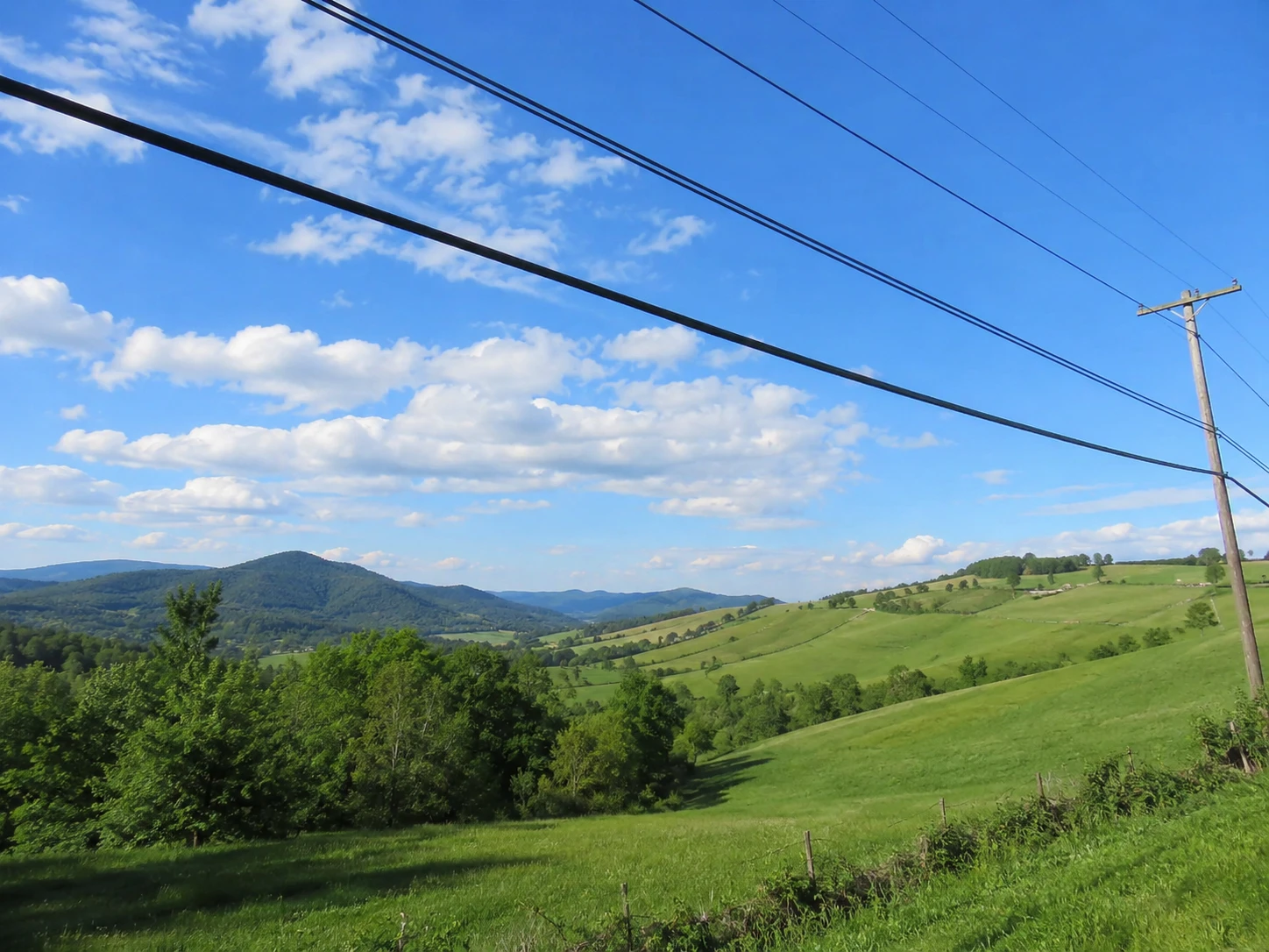Countryside landscape with electrical power lines cutting across the sky